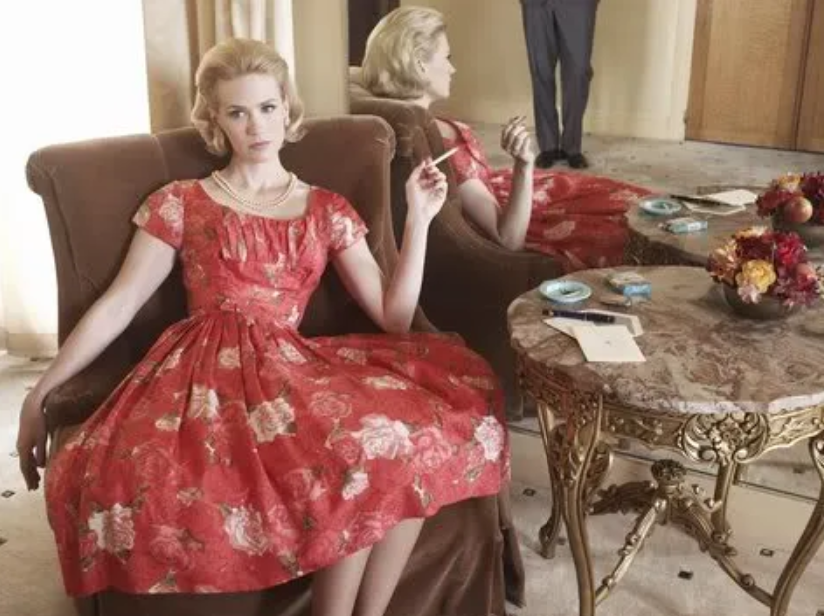 Mad Men - Betty holding cigarette sitting in dress