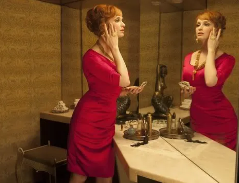 Mad Men - Joan Halloway in pink dress looking in mirror